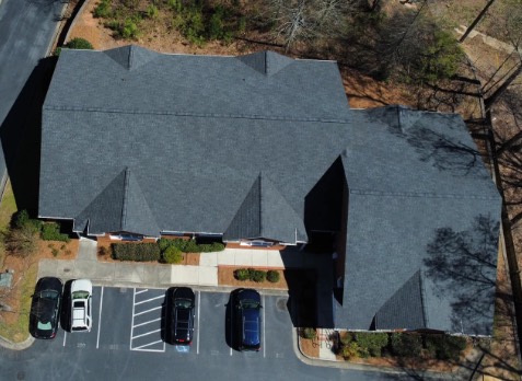 Alpharetta roofing Image of a brick house with newly installed dark gray shingled roof