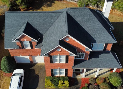 Alpharetta roofing Image of a brick house with newly installed dark gray shingled roof