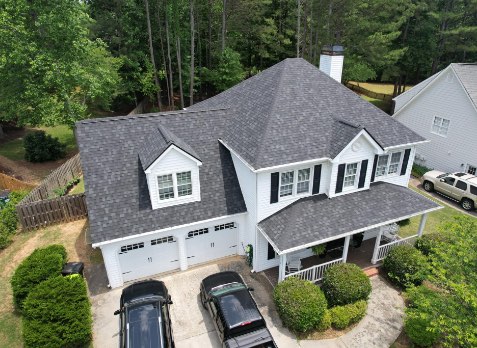 Alpharetta roofing image of a white house with newly installed gray shingled roof