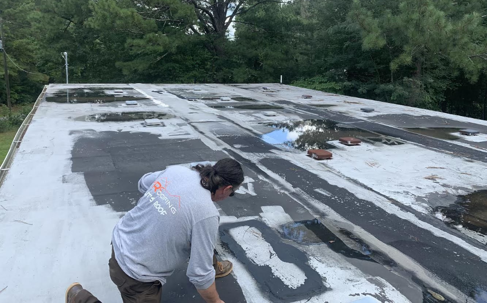 Photo of a commercial roofer inspecting a commercial flat roof