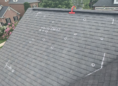 Image of gray shingles on a roof with roof inspection markings