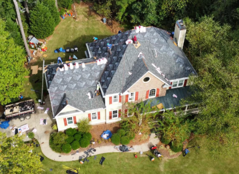 Overhead image of a residential roof in Cumming Georgia being repaired after storm damages