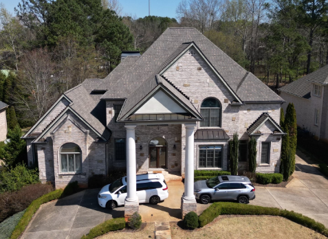 Alpharetta roofing Image of a brick house with newly installed brown shingled roof in Douglasville Georgia