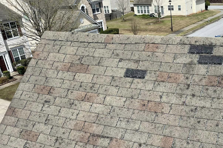 Roof Storm Damage photo of gray shingles damaged by hail