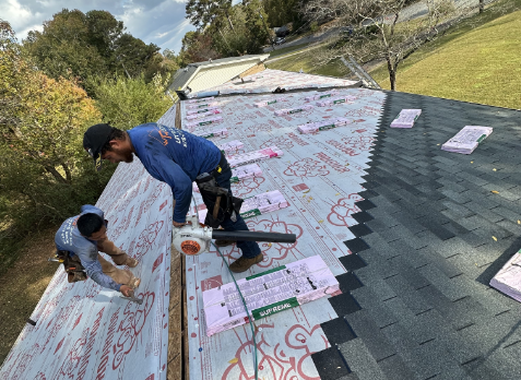 Photo of a Nashville roofers on a roof having the shingles replaced.