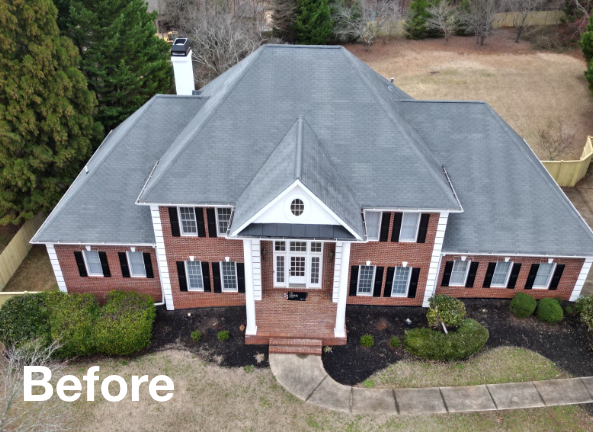 Photo of a gray asphalt residential roof on a brick house after roof replacement