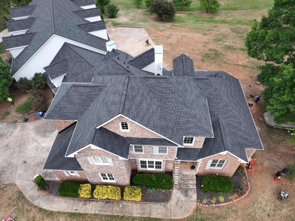 Background header Image of a brick house with newly installed gray shingled roof in Birmingham Alabama