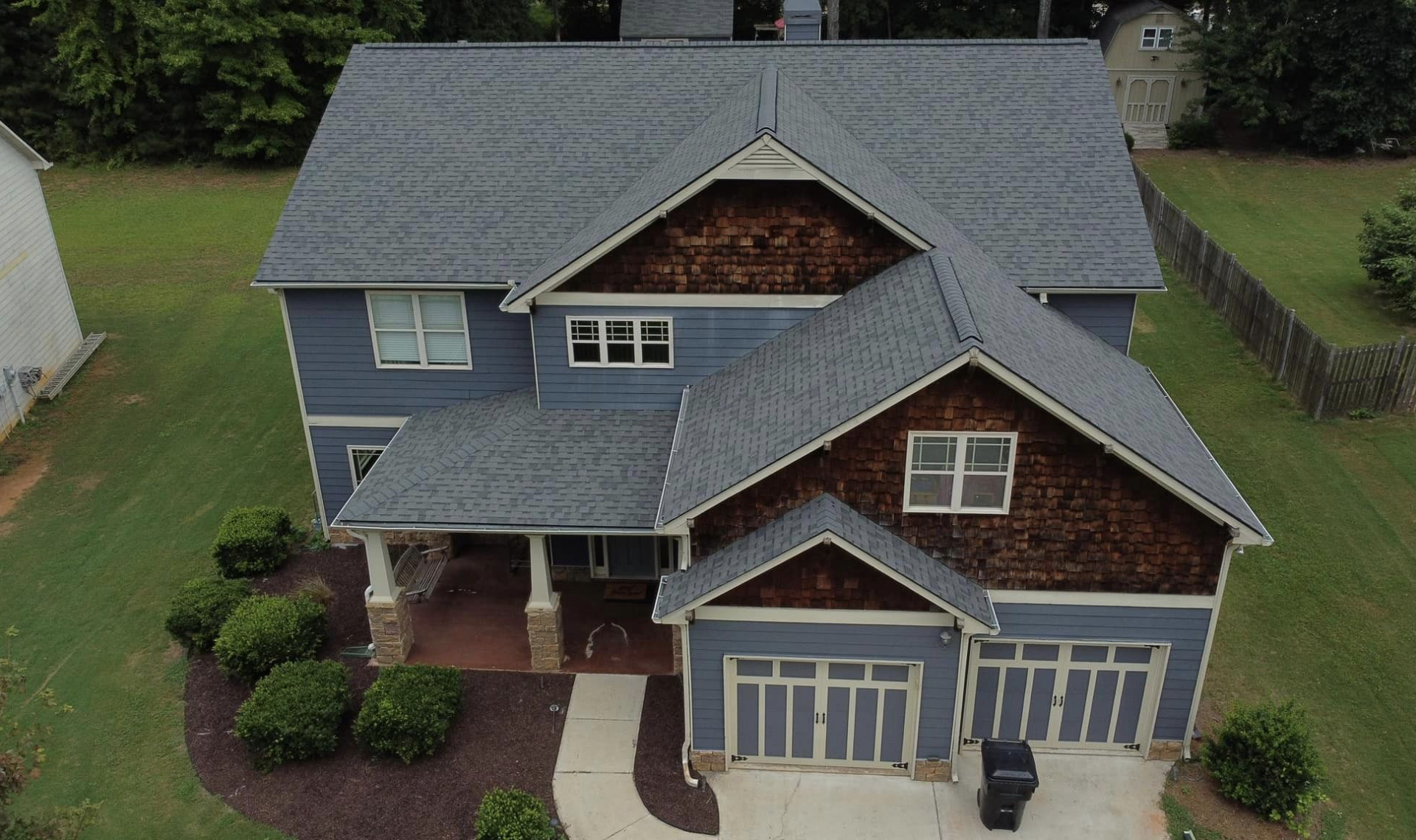 Photo of brick house with new gray shingled roof