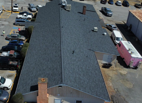 Kennesaw commercial roofing Image of a brick building with newly installed dark gray shingled roof