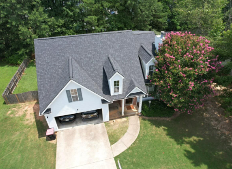 Kennesaw roofing Image of a white house with newly installed gray shingled roof