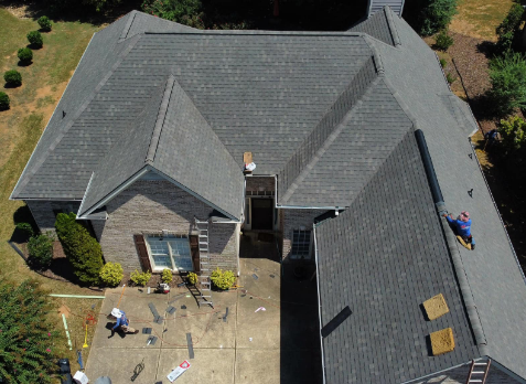 Image of roofer on a roof repairing damaged shingles in Trussville