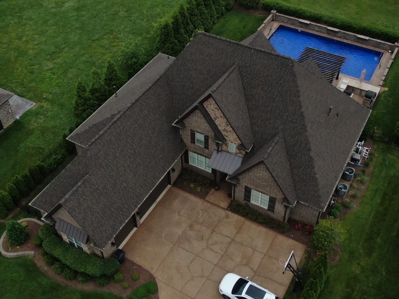 Image of a brick house with newly installed gray shingled roof