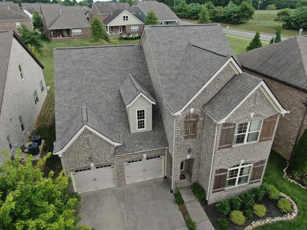 Photo of a Franklin brick home having its roof repaired after storm damage