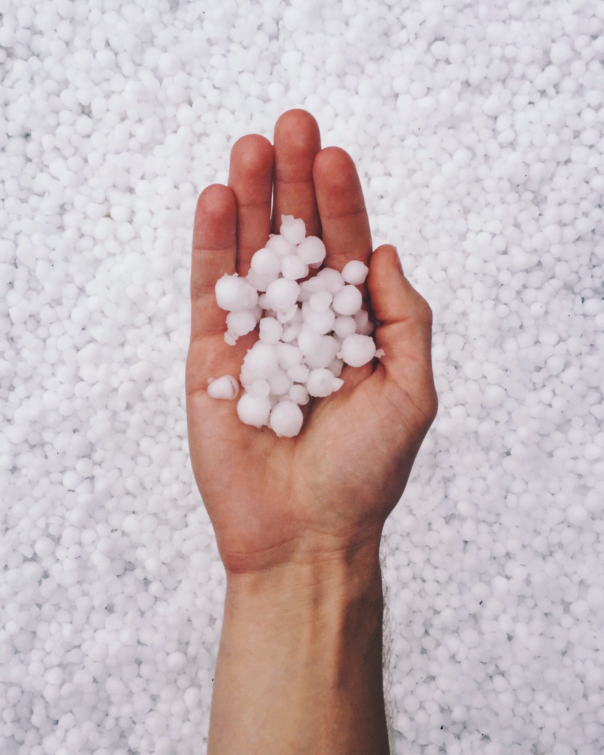 Hail stones being held in hand after hail storm damage