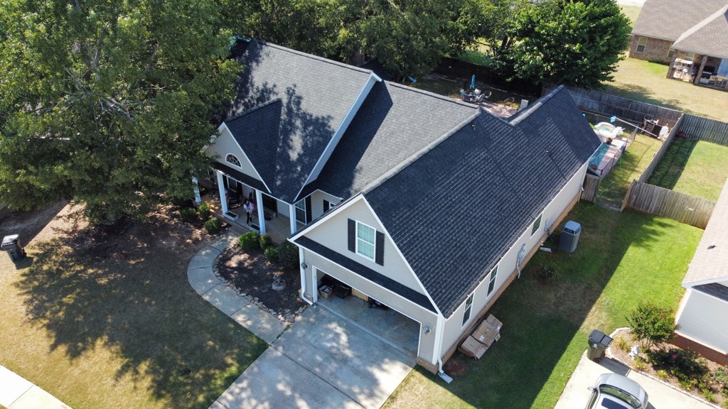 Cheap roof installed on house. Gray asphalt shingles on a white house.