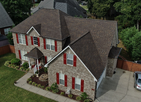 Brentwood roofing Image of a brick house with newly installed brown shingled roof