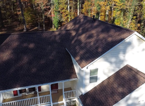 Douglas roofing Image of a white house with newly installed brown shingled roof