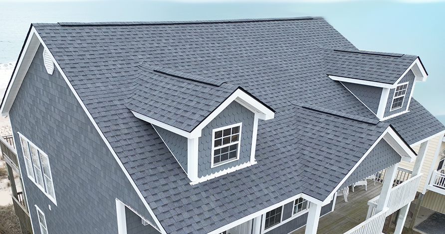 Closeup photo of a roof of a gray house with gray Atlas shingles