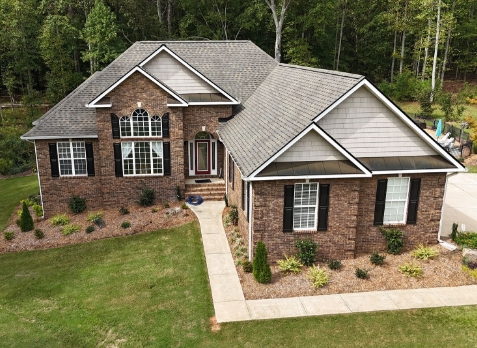 Image of white residential house with a new shingle roof in Carrollton