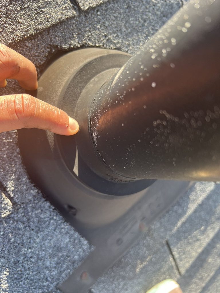 Closeup image of a roofers hand pointing out potential issues during roof maintenance