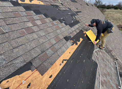 Upclose Image of a roofer replacing a gray commercial roof