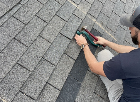 Roofer repairing of a damaged shingle in Hendersonville