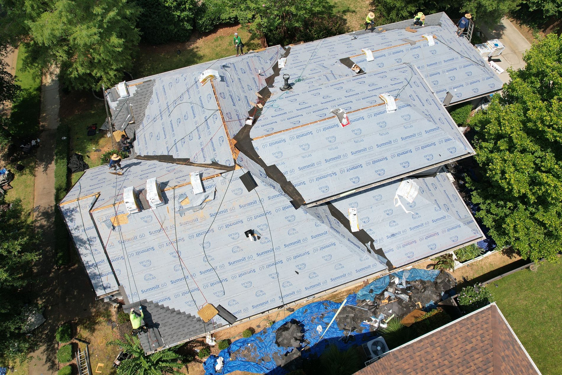 aerial image of roofers from local roofing company replacing a residential roof