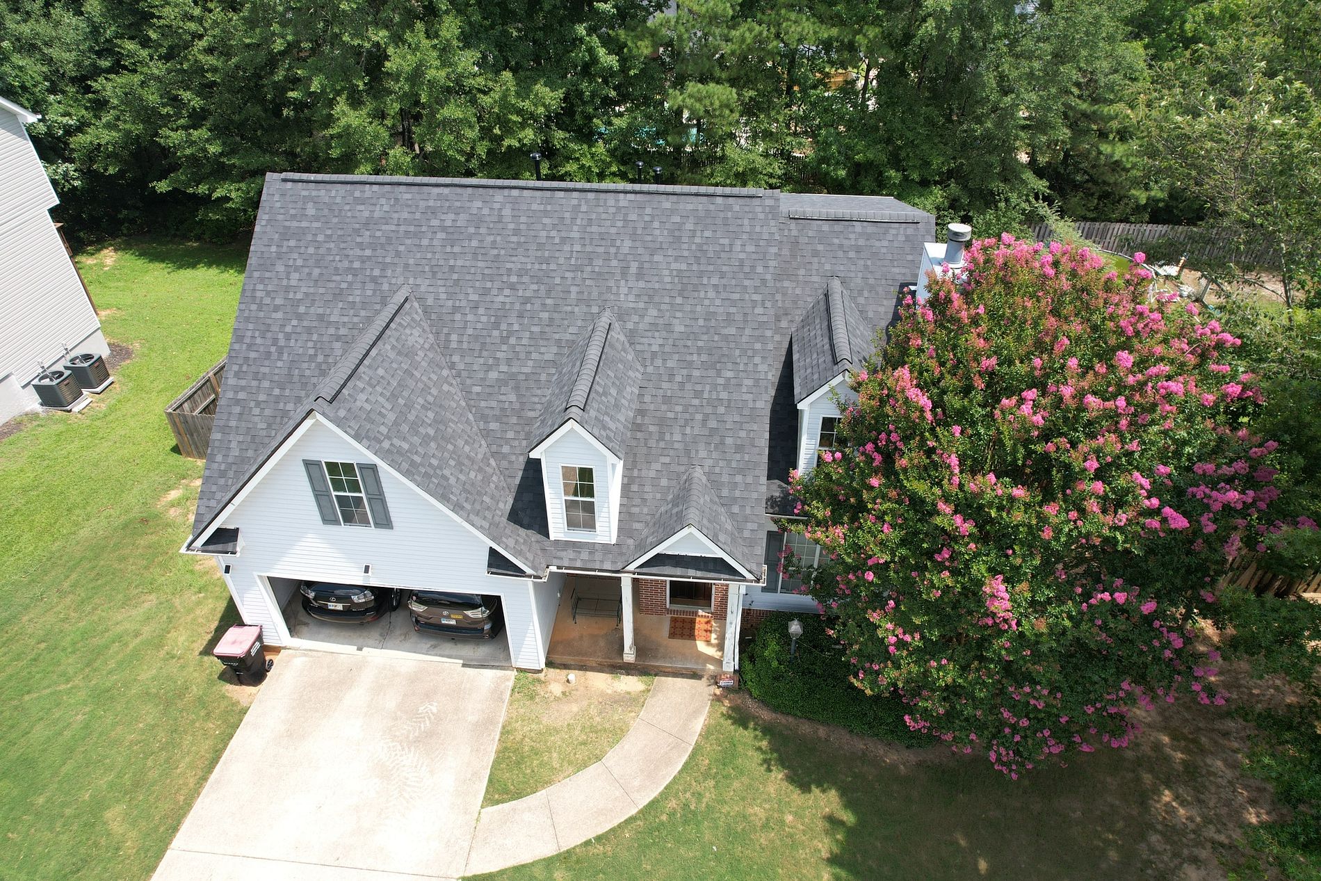 image of Local roofing company newly replaced roof on a residential home with gray shingles