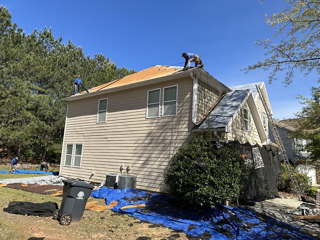 image of Local roofing company replacing a roof on a residential home