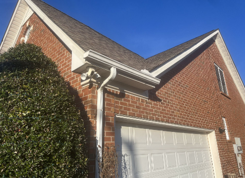 Up close image of a new gutter installed on a brick house