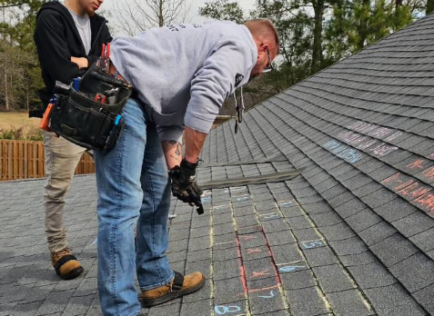 Image of a roofer on a residential shingle roof during roof inspection