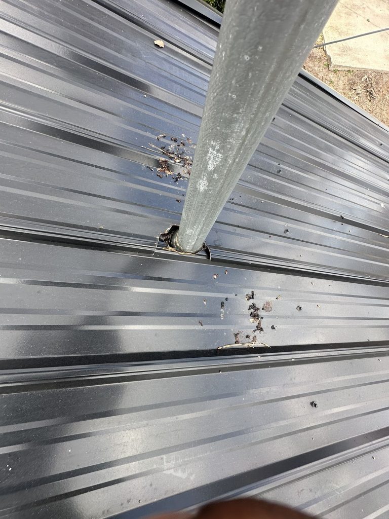 Upclose image of a metal roof with metal eroding around a vent needing rooftop repairs