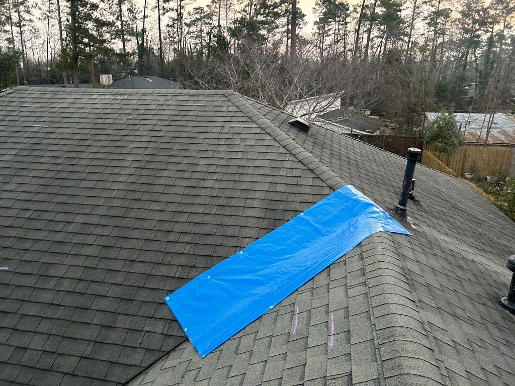 Image of a roof with a blue tarp needing roof repairs