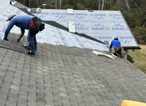 Photo of a Dallas home with roofers on a roof during a roof replacement