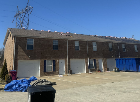 Image of a commercial roofing replacement with new brown shingles in progress