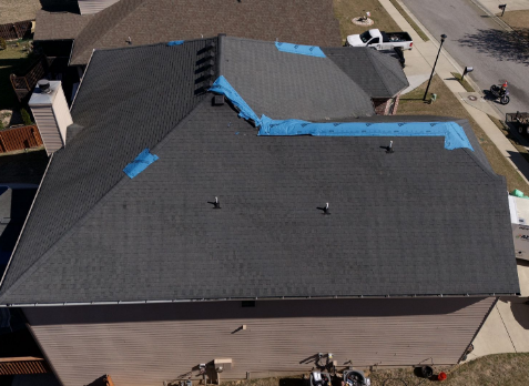 Image of a roof with multiple blue tarps needing roof repairs