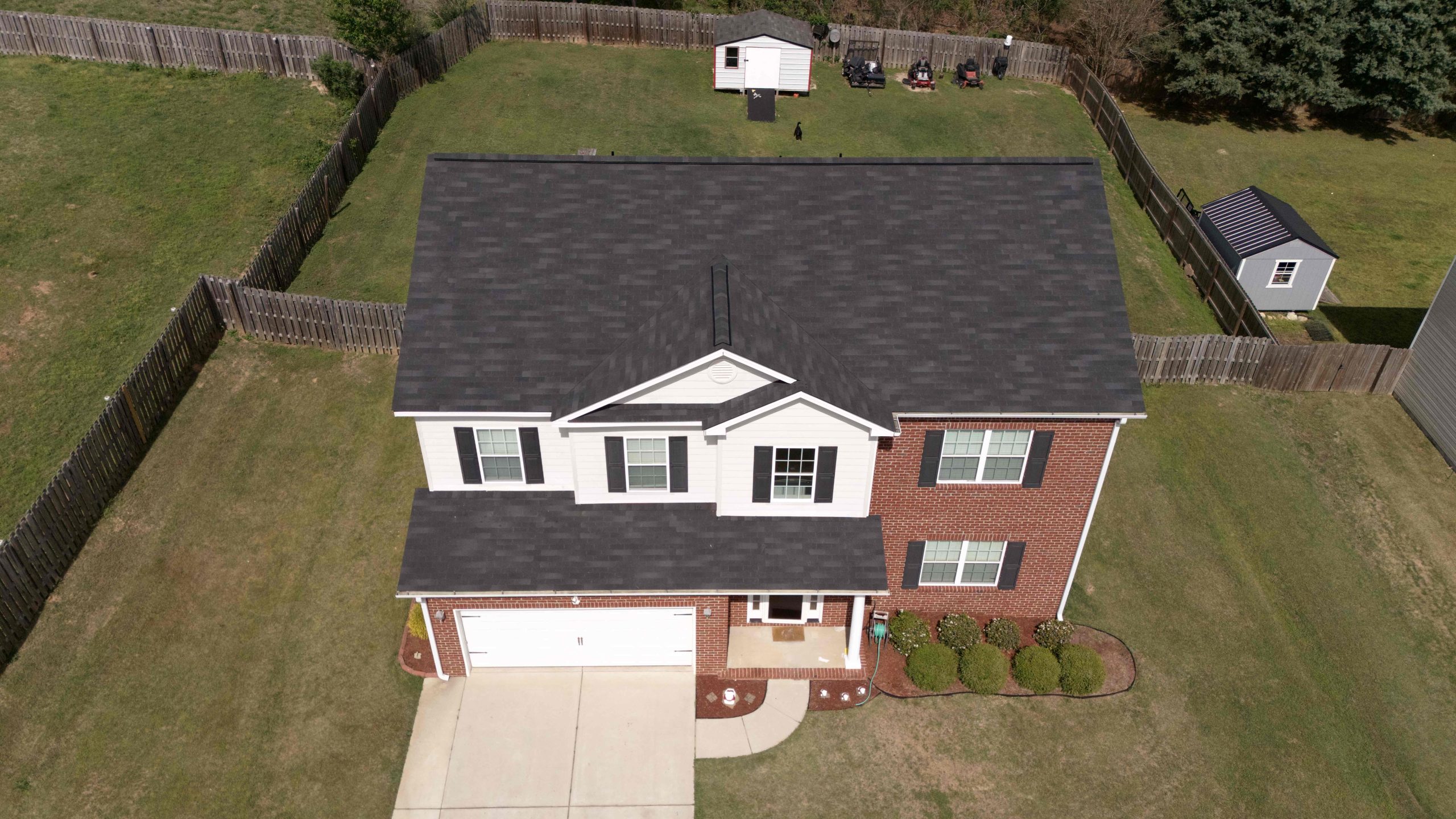 Overhead image of brick house with newly installed asphalt shingles