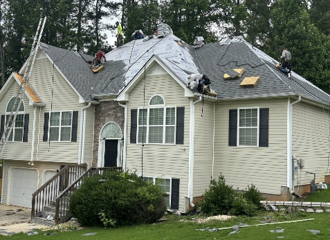 Roofers on a house with during a roof replacement