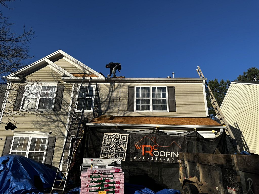 Image of a roofer on top of roof during a residential roof replacement
