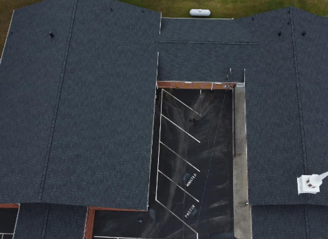 Top down photo of a large gray asphalt commercial roof after roof replacement
