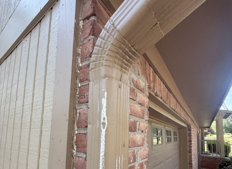 Close-up of white gutter downspouts needing repair