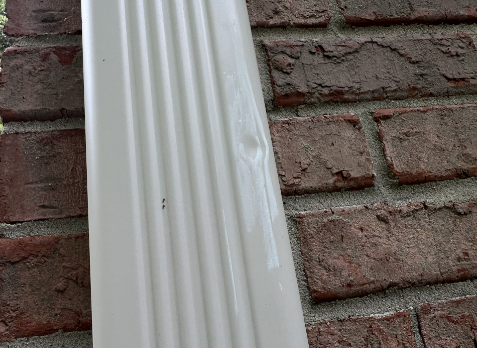 Close-up of white gutter downspouts needing repair