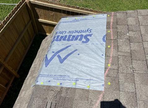 Photo of roof with tarp after storm damage.