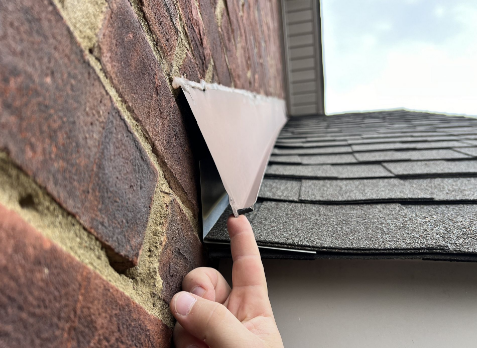 Image of a roofers hand inspecting the flashing of a roof during a roof inspection in Hermitage.