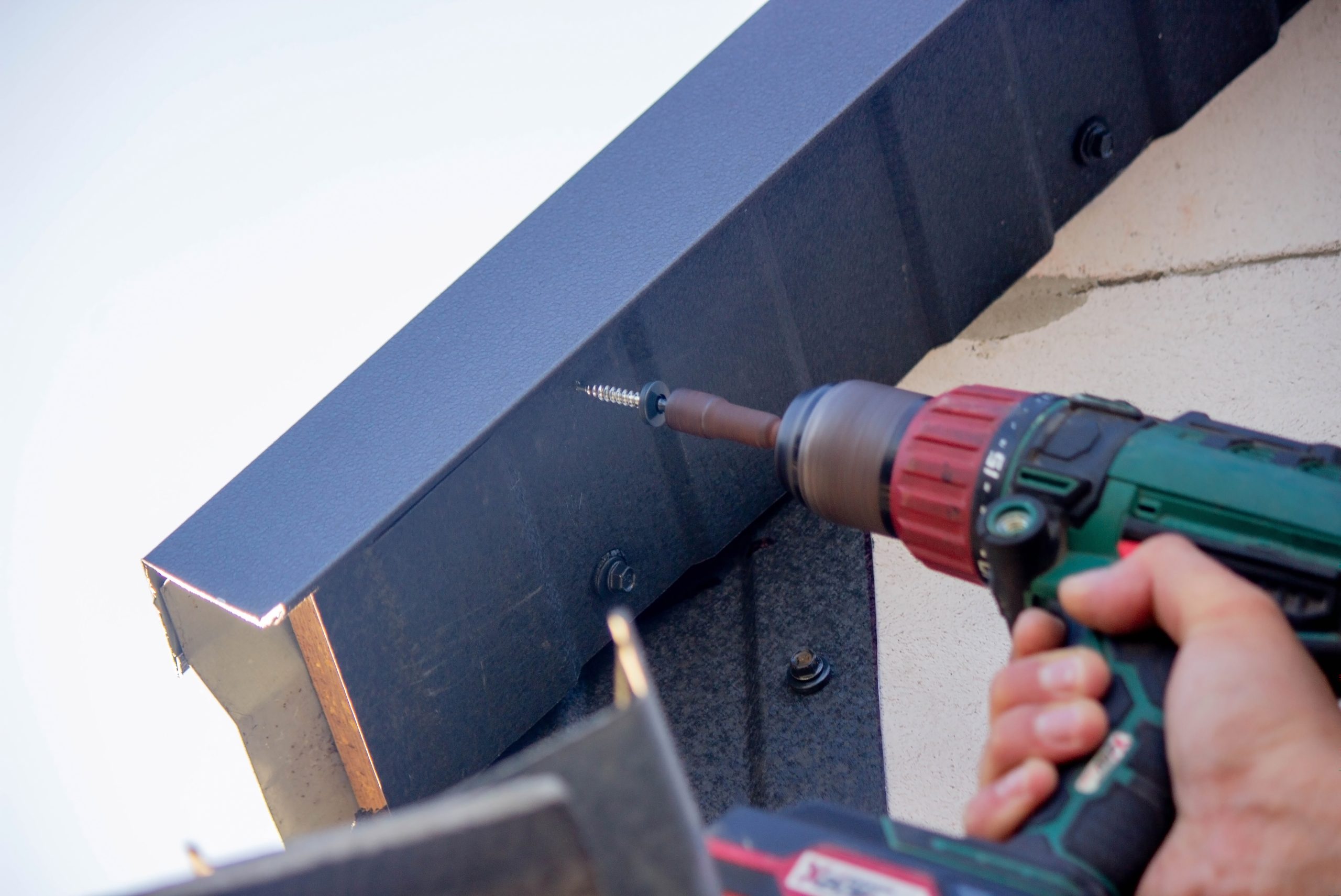 A man repairs the roof, installing roof drip edge.