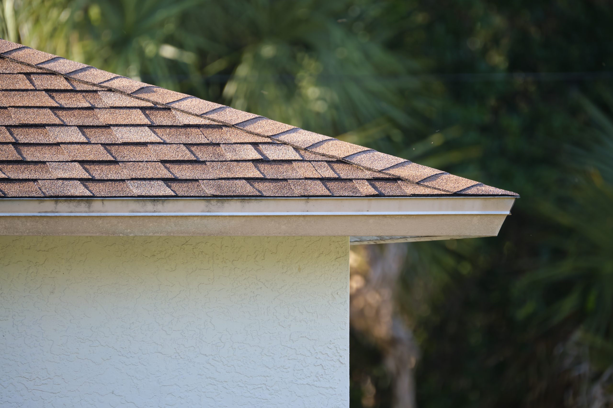 Closeup of house roof top covered with asphalt shingles. Waterproofing of new building with roof drip edge.