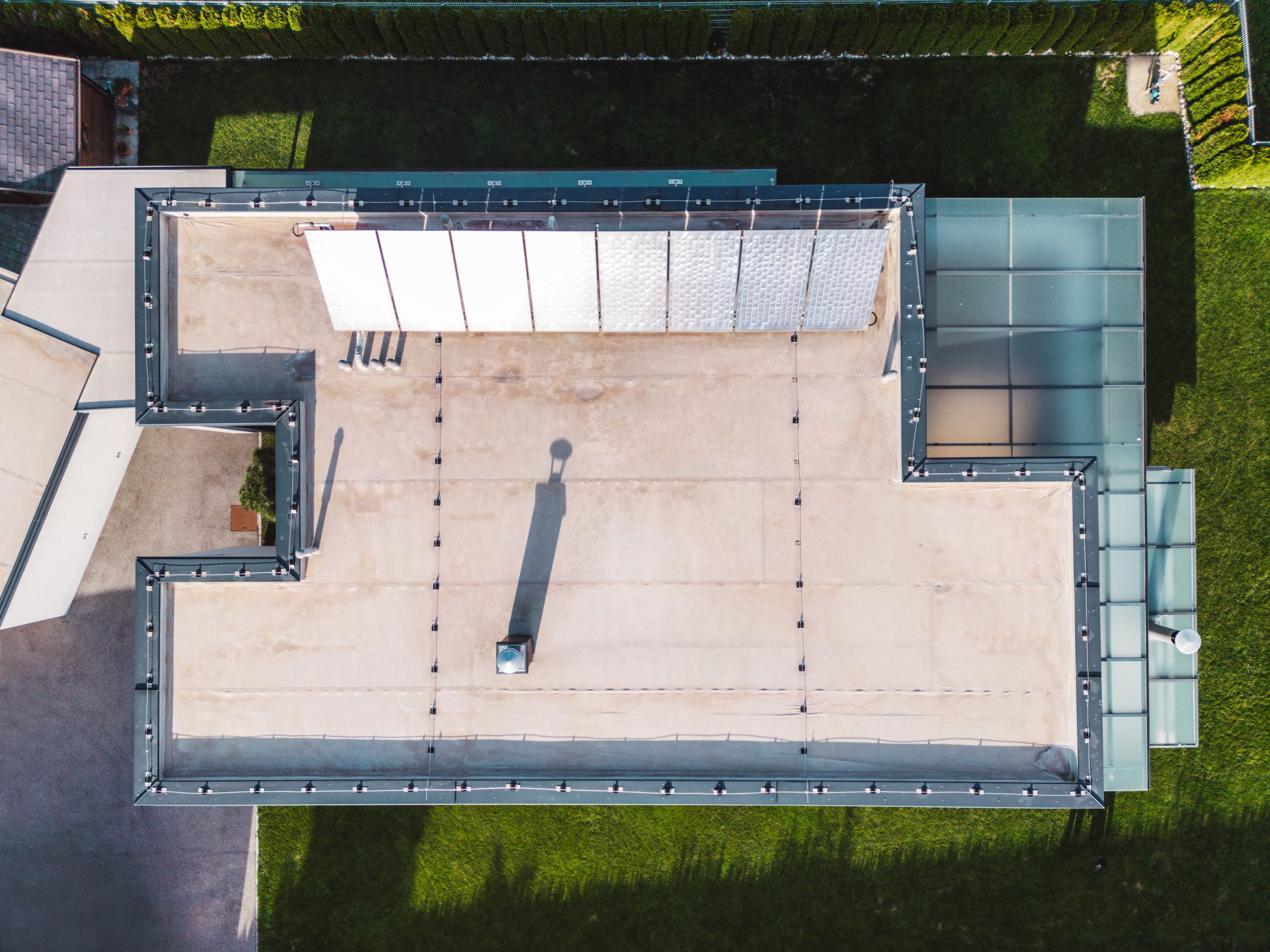 Aerial view of a modern house with solar panels on a flat roof after repairs