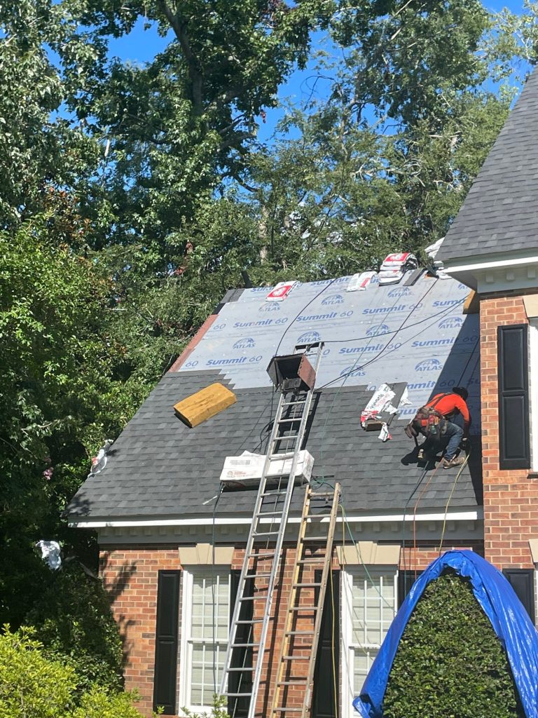 Roofers on a house with during a roof replacement in birmingham