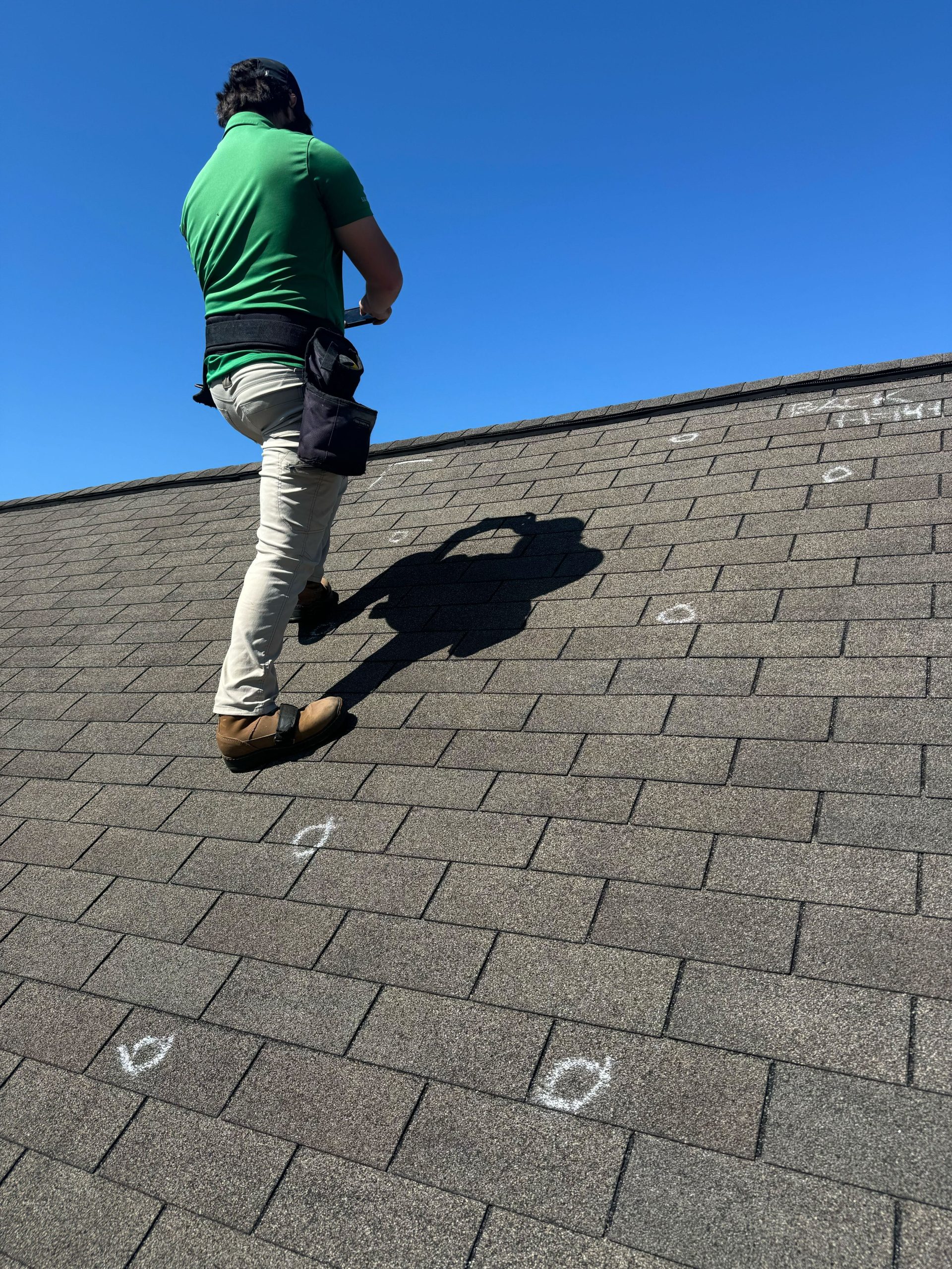Photo of a top roof contractor on roof inspecting and determining roof repair cost