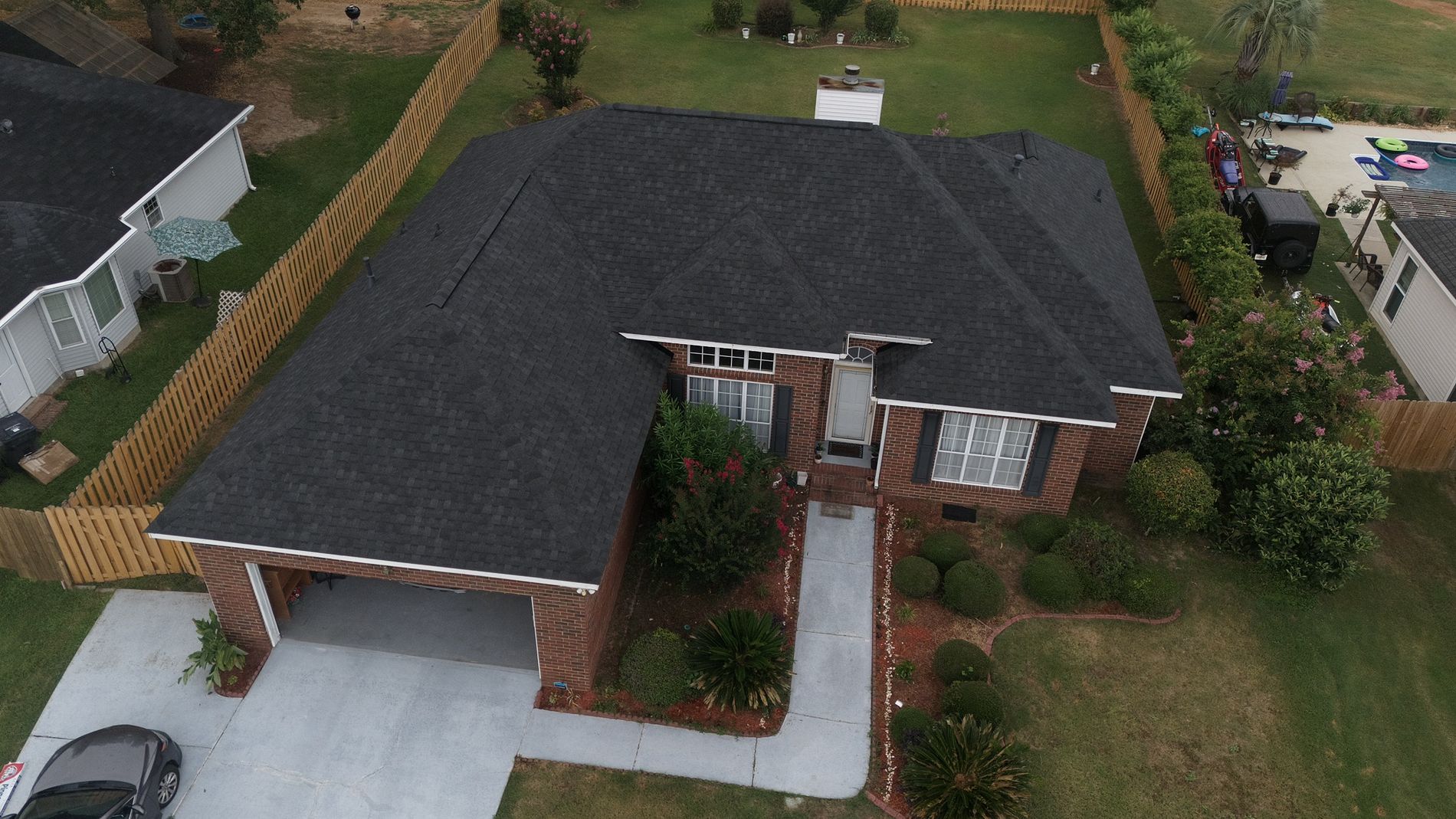 Image of a new dark gray asphalt shingled roof replacement on a house.